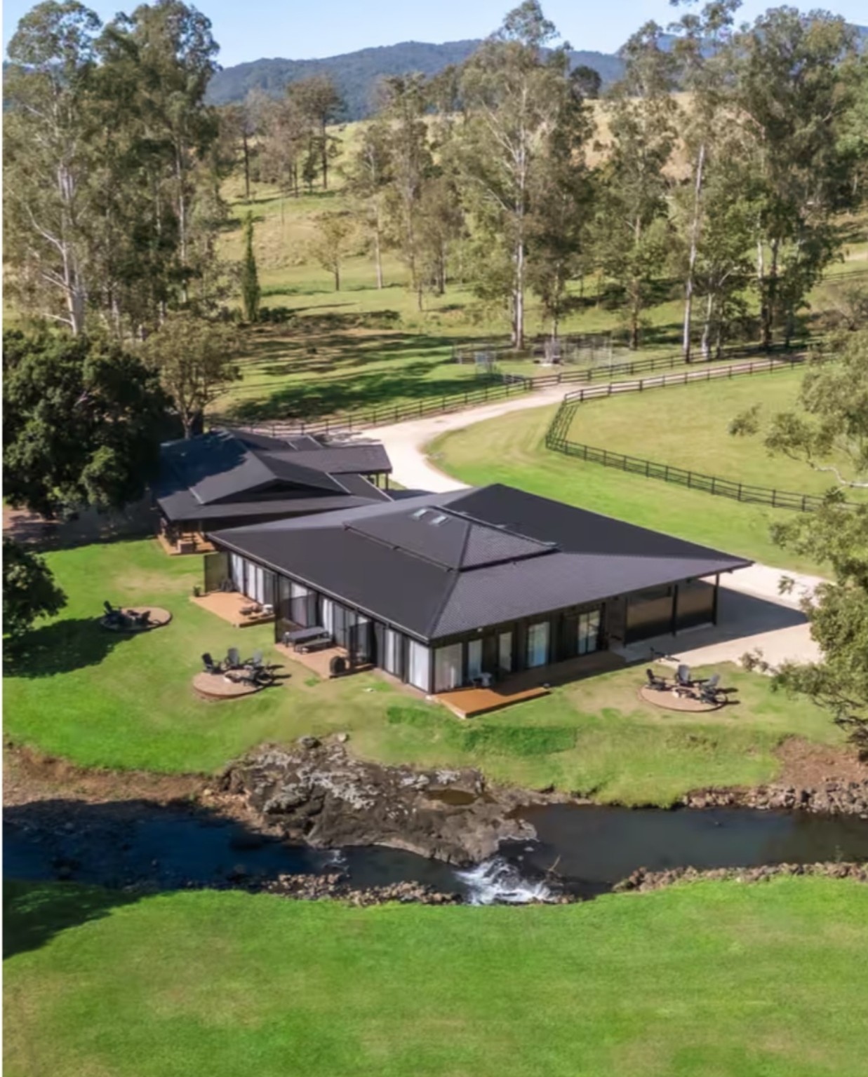 Aerial view of the completed rural retreat beside a creek